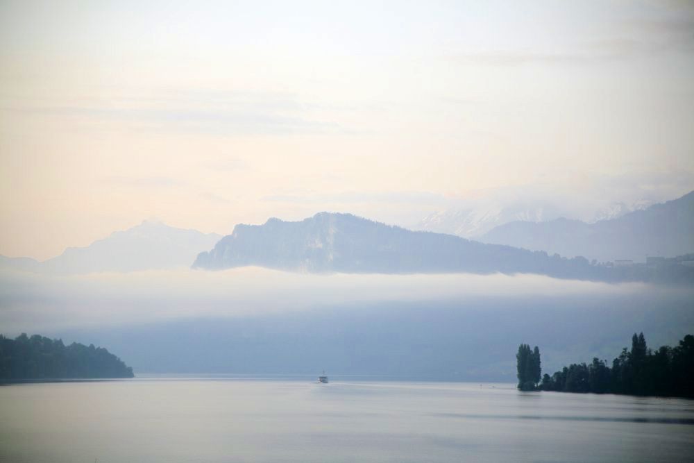 A peaceful lake and mountain beneath a foggy, overcast sky