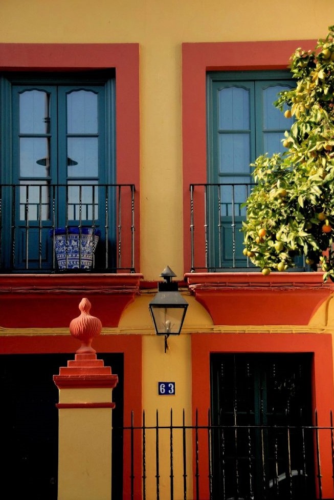 A bright yellow house with red trim