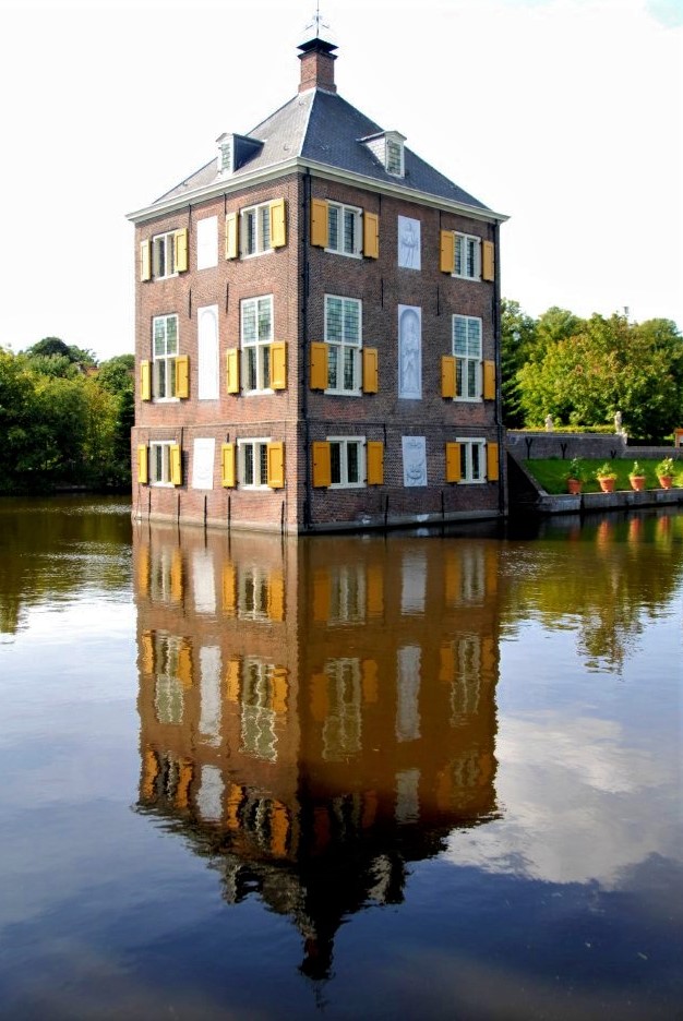 The Hofwijck, a seventeenth-century Dutch mansion made of red brick and adorned with bright orange shutters, sits in the middle of a clear and calm canal