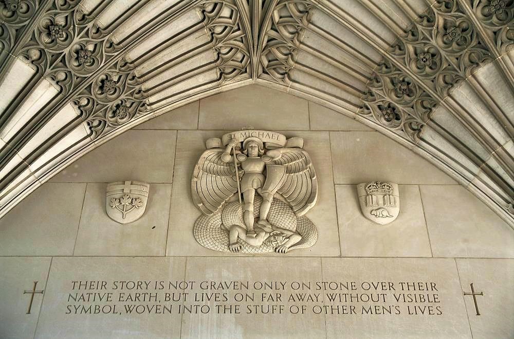A stone fresco inside a church featuring a cherub at the center surrounded by ornate arches
