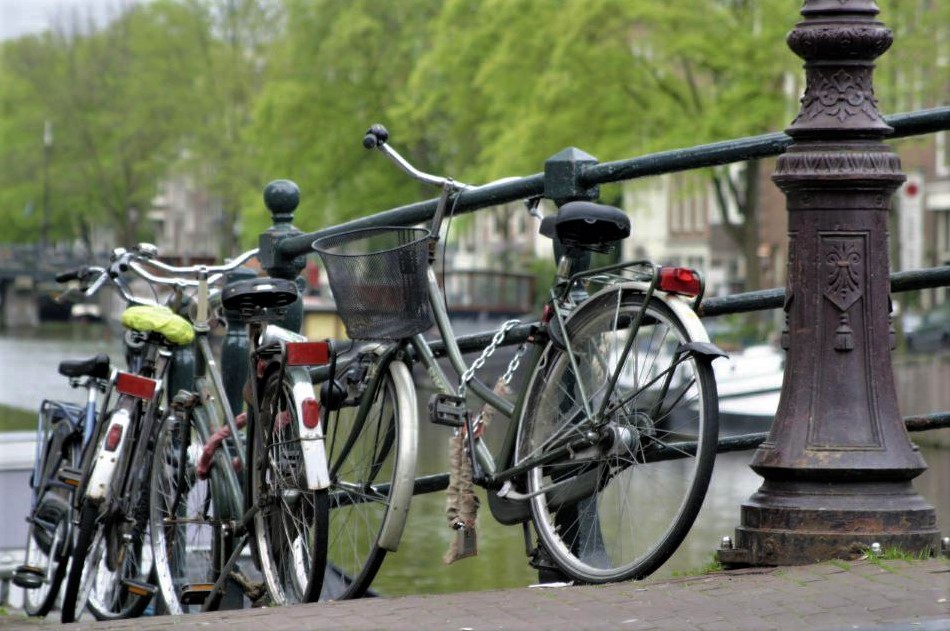 A row of bicycles leaning against a metal railing