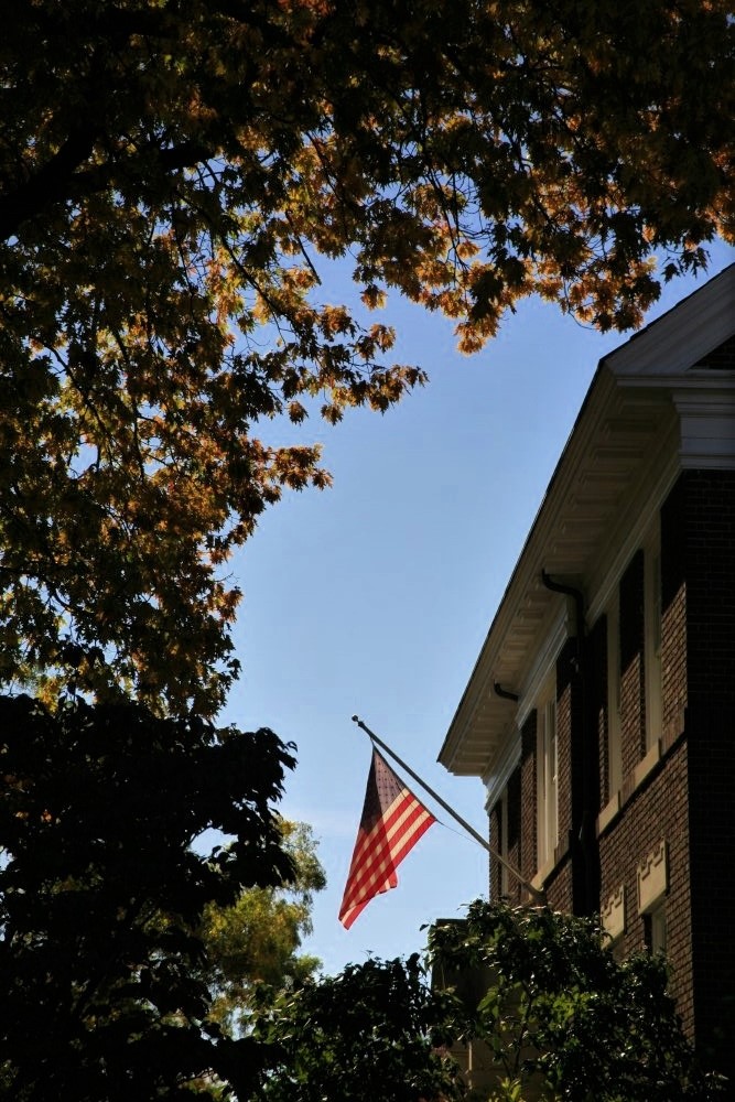An American flag hanging from a residential home