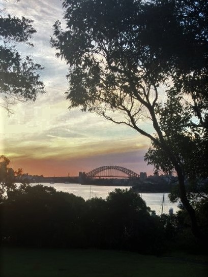 A distant view of Sydney Harbour Bridge at sunset