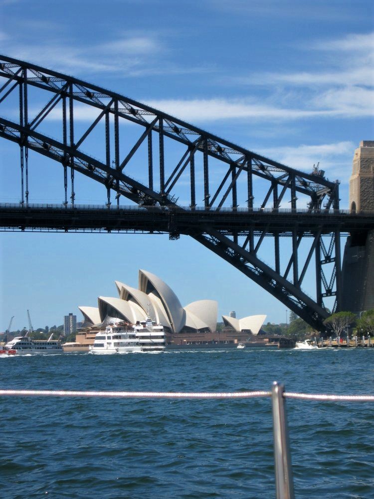 Sydney Harbour Bridge spanning in the foreground with the Sydney Opera House visible in the distance