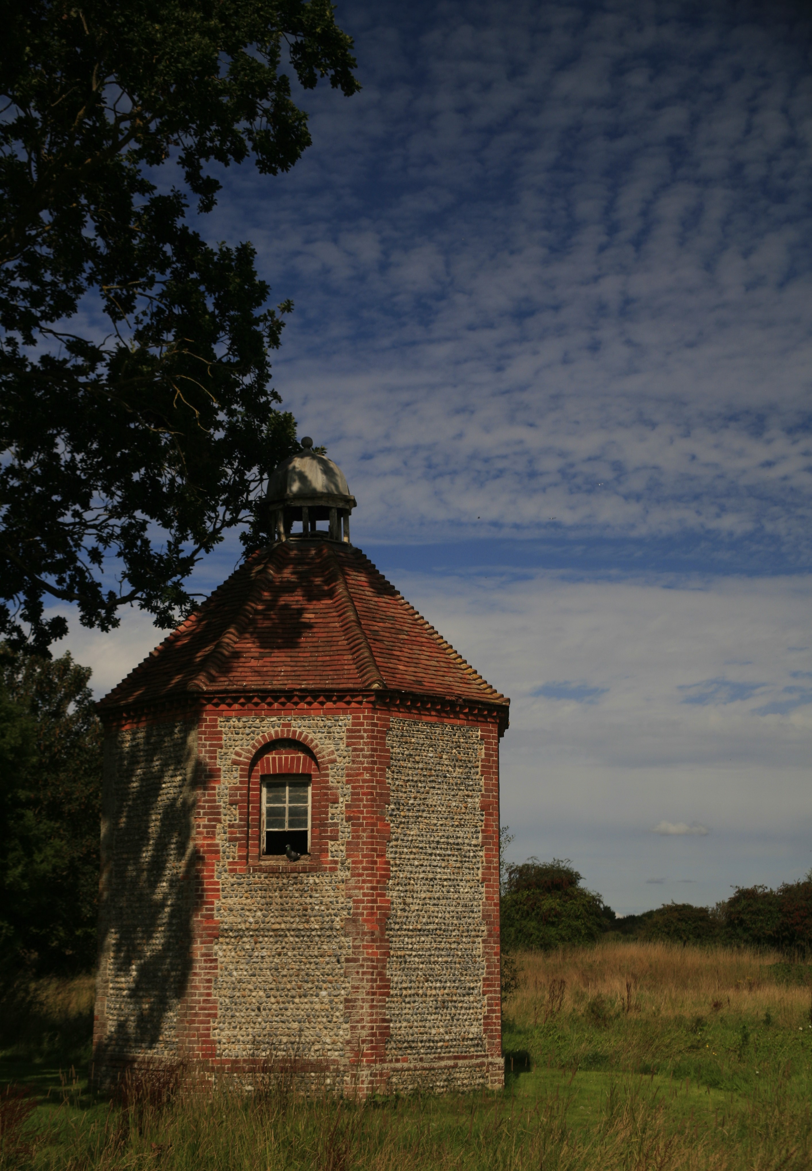 A small stone building in a meadow