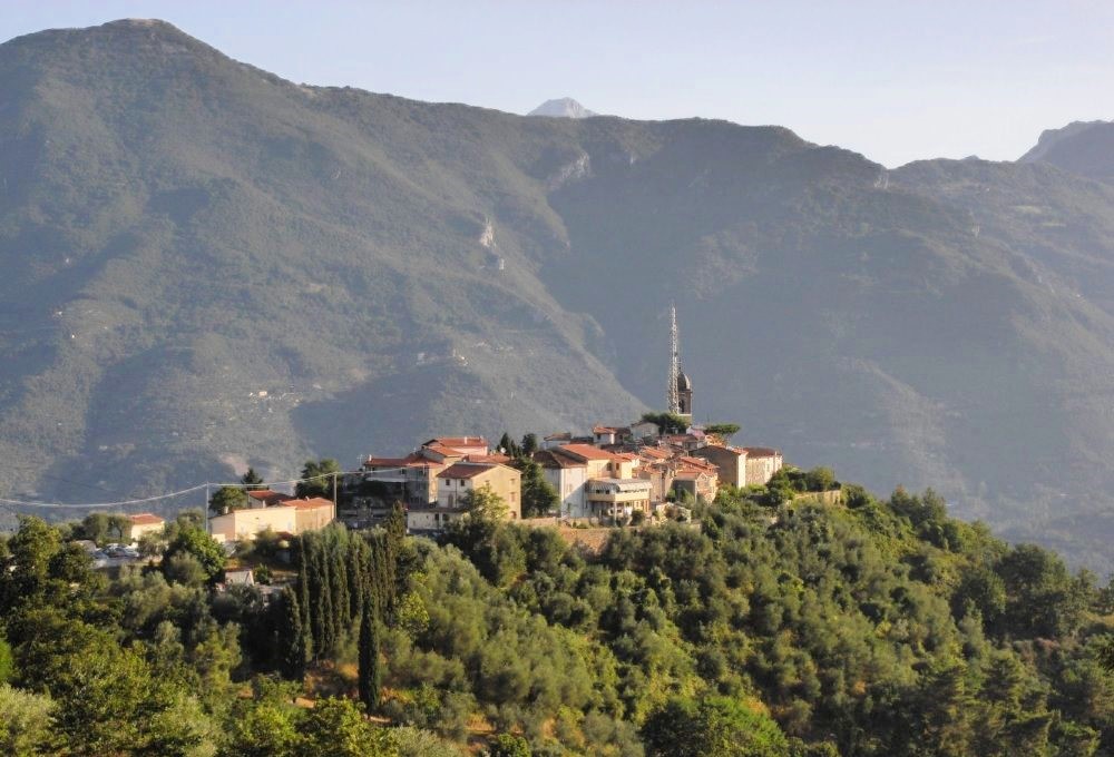 An Italian villa perched on the crest of a hill in the mountainous countryside