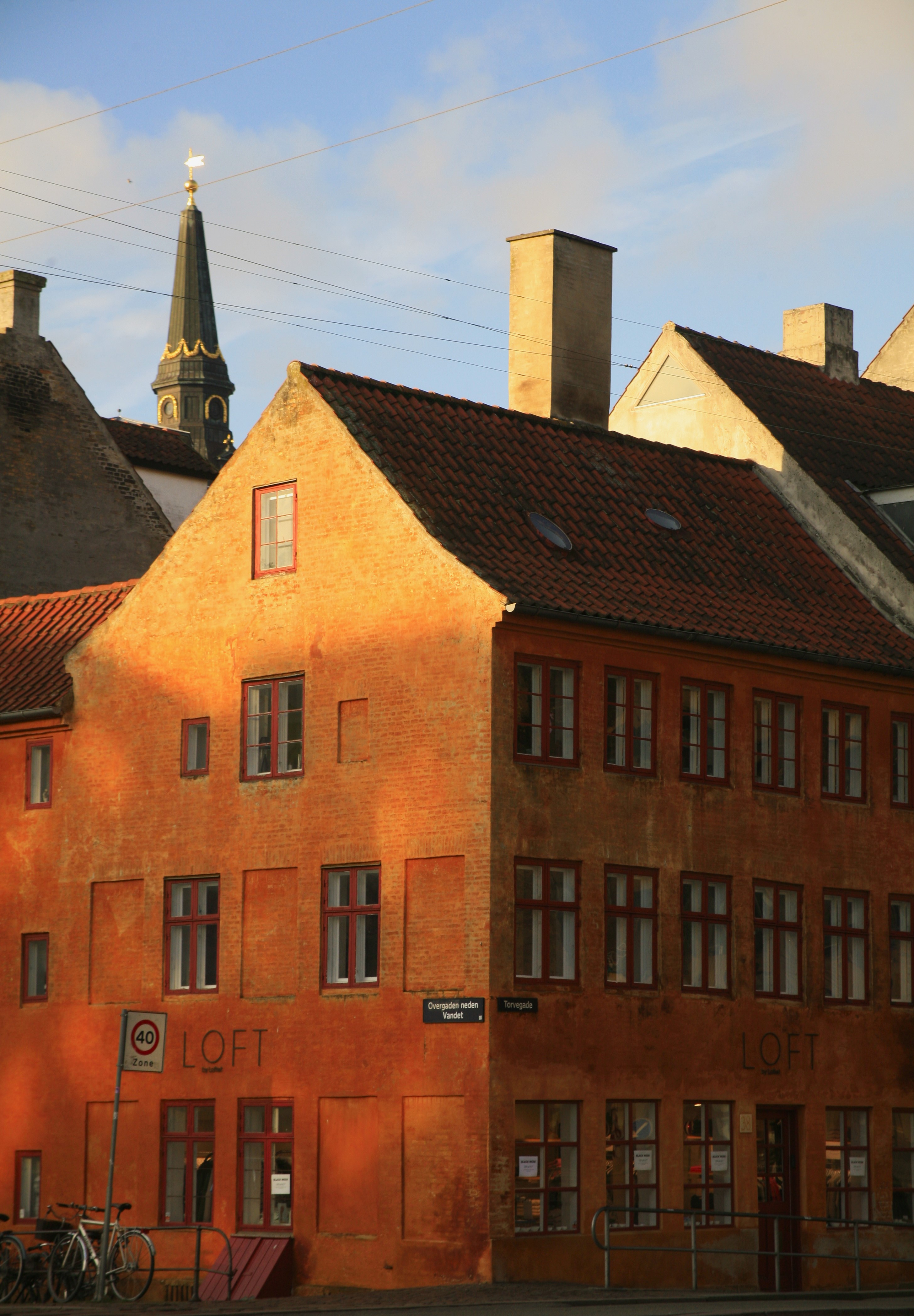 An old red brick house, one side washed in golden afternoon sunlight