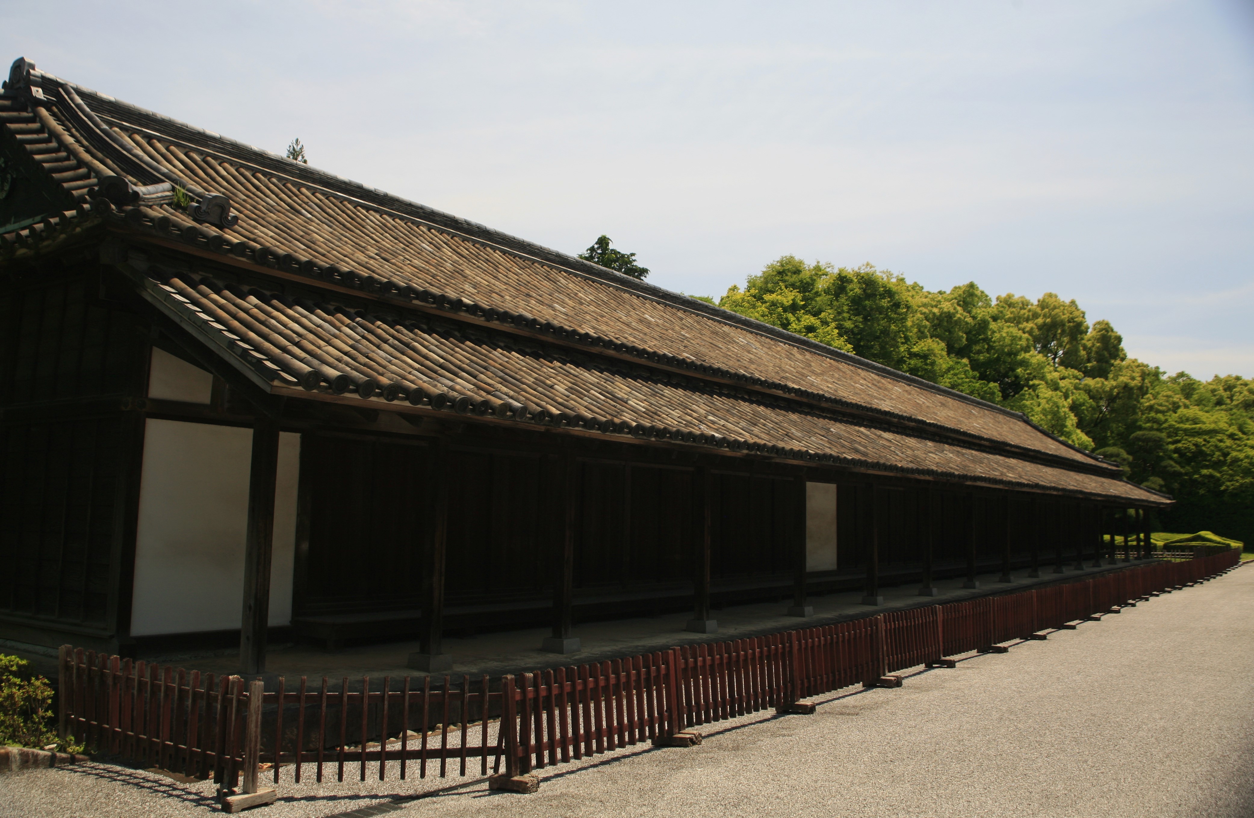 A long wing of the Imperial palace stretches into the distance with green trees visible in the background